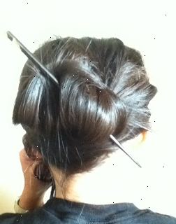 Hvordan man kan sætte dit hår op med spisepinde. Find et par spisepinde.